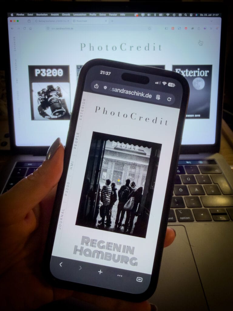 Smartphone in einer Hand, auf dem Display wird diese Seite angezeigt. Im Hintergrund ein Laptop mit dieser Seite. Foto: SaSch
