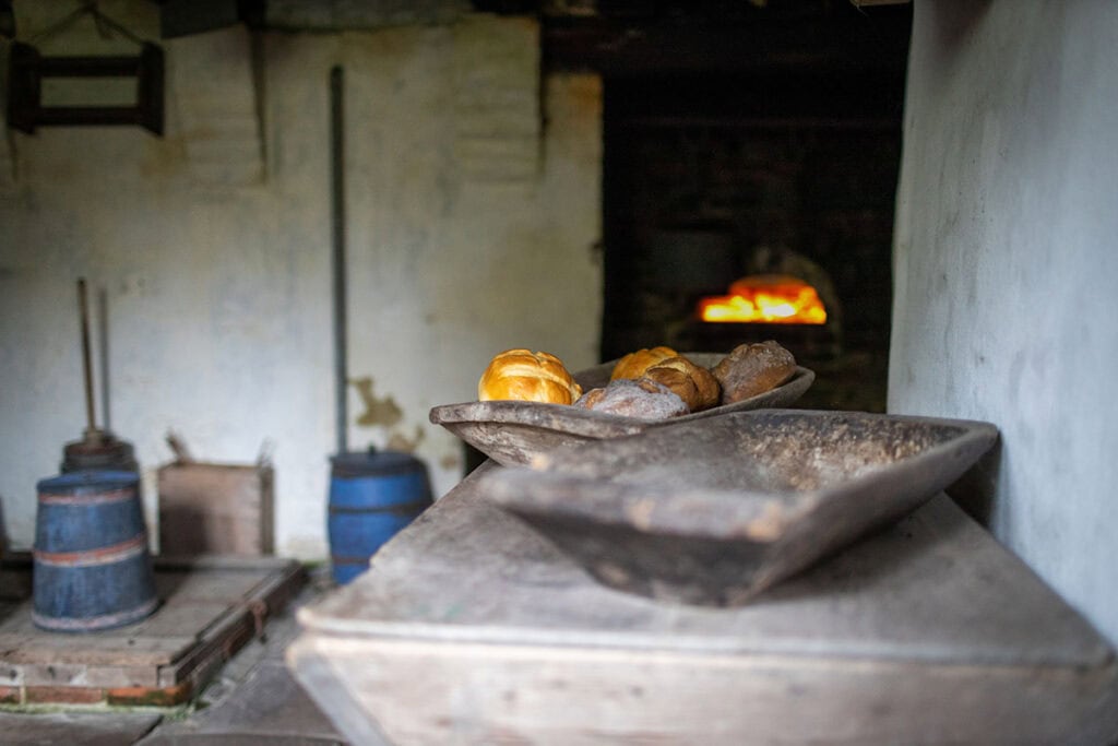 Historischer Ofen mit Holz und Kohle in einer alten Küche.