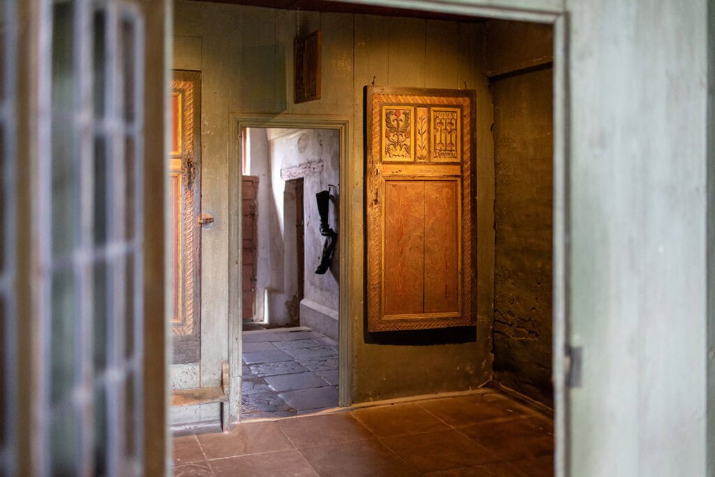 Alte, kunstvoll bemalte Holzschränke in einem historischen Raum.